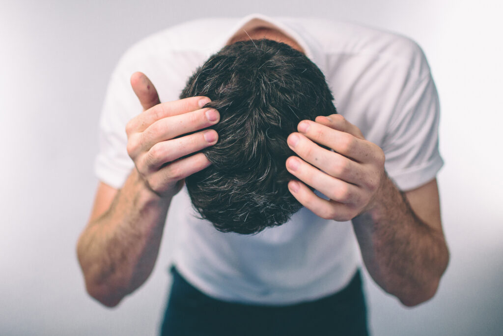 Man checking hair for hair loss on scalp