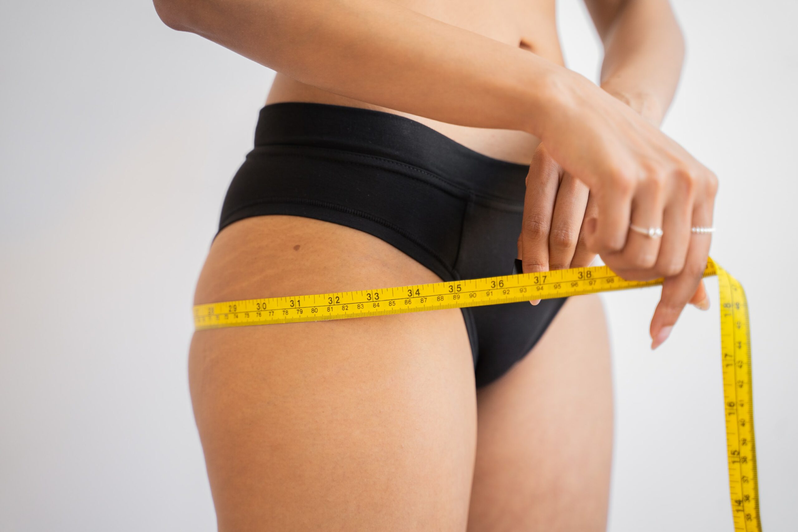 Woman losing weight measuring waist