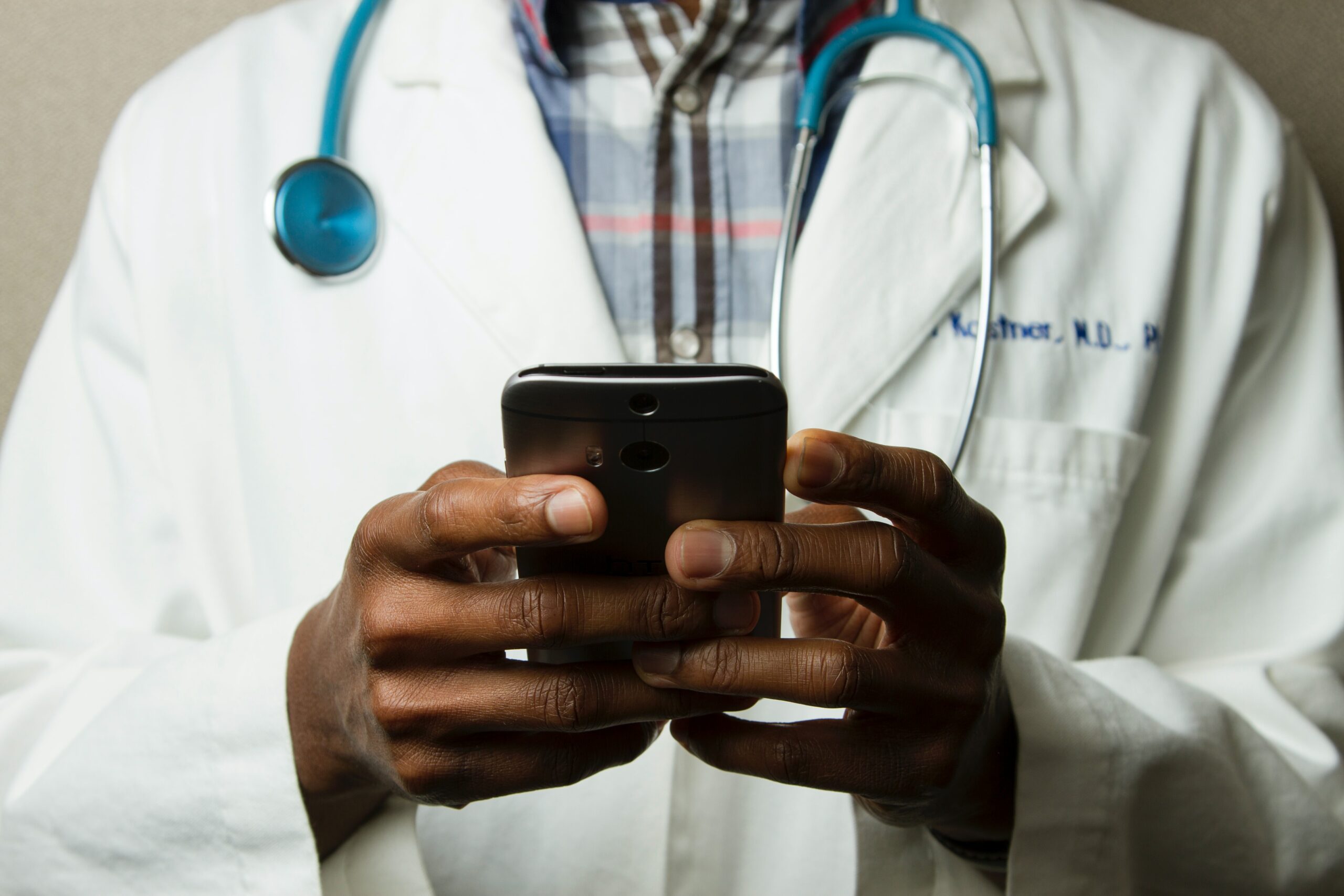 Trichology Doctor with stethoscope diagnosing hair loss on phone