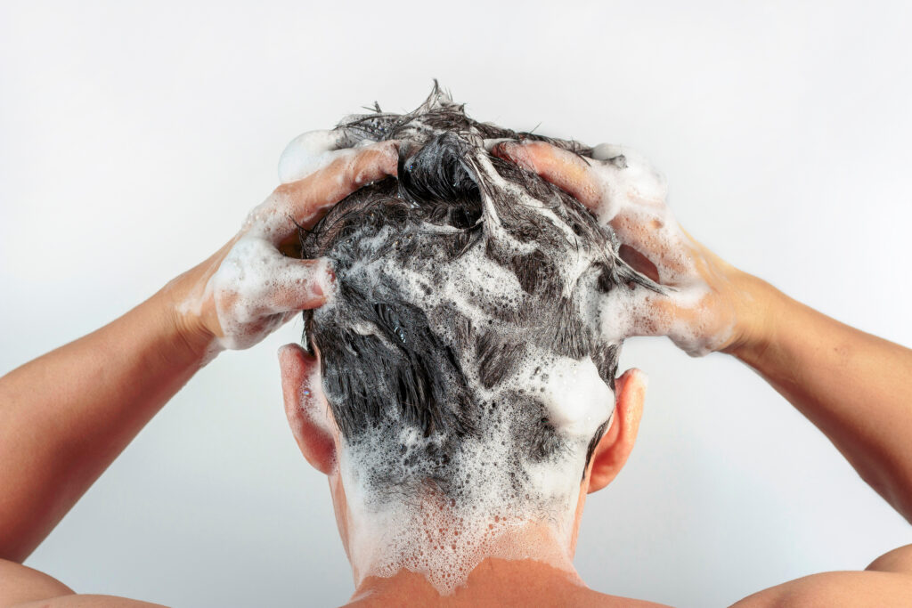 A man shampoos his hair.