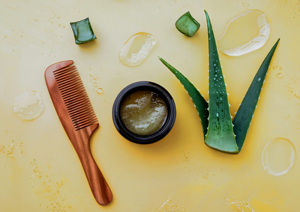 Hair care wooden comb with Aloe Vera hair care on background