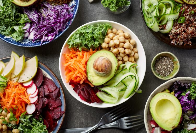 Vegane Lebensmittel in Tellern und Schüsseln auf einem Tisch angeordnet